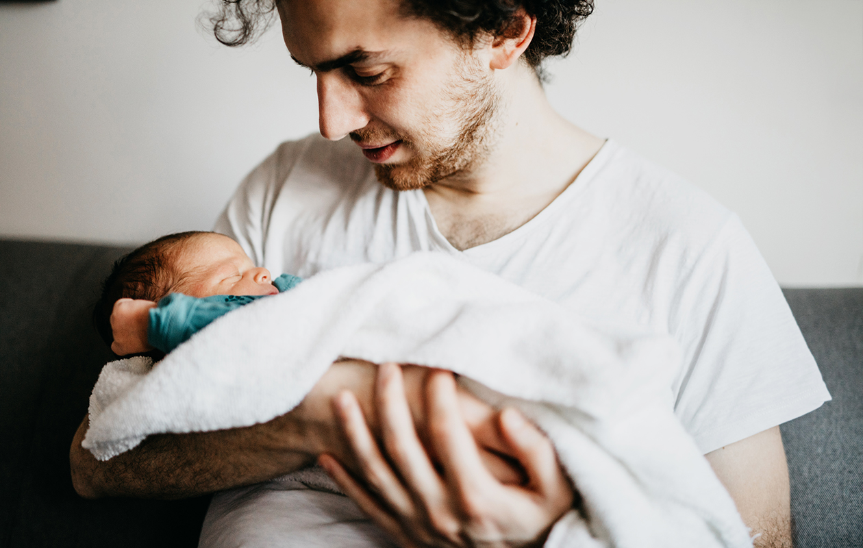 un père tient son nouveau-né dans les bras