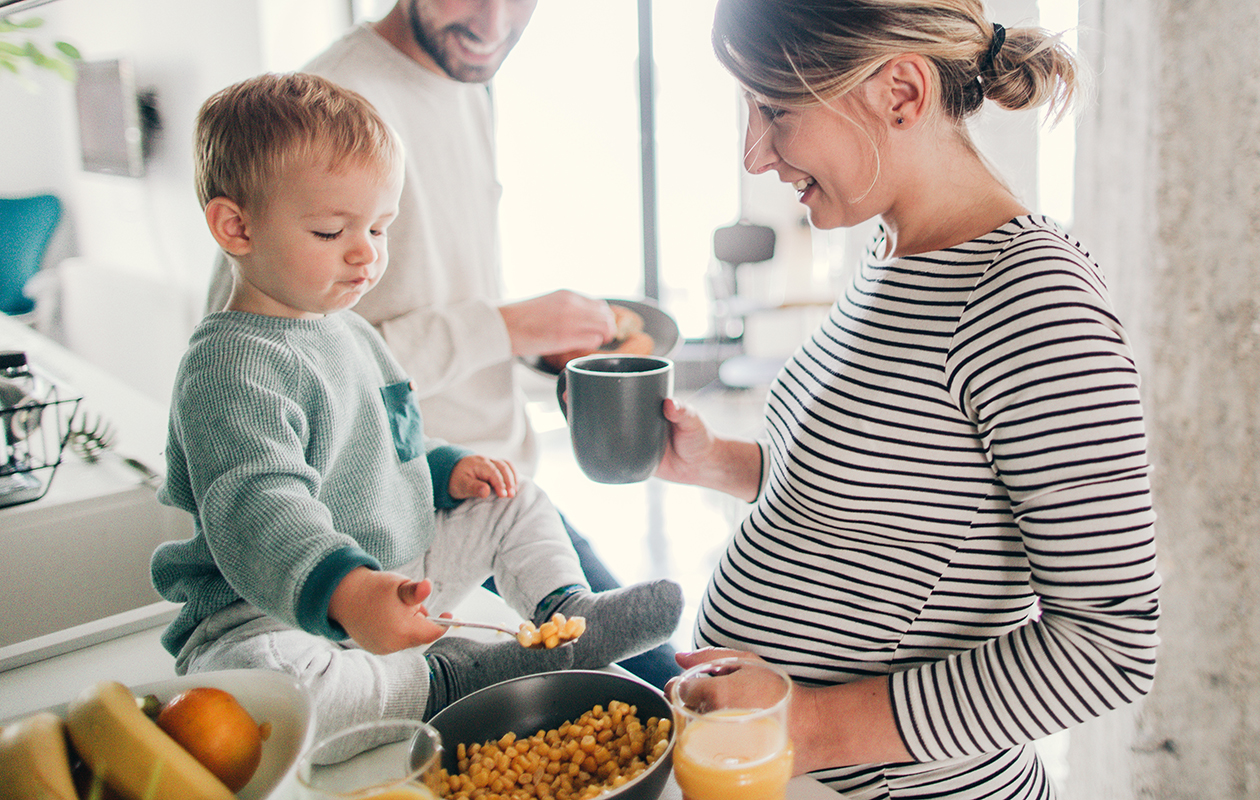 une femme enceinte, son compagnon et leur petit garçon préparent un plat de pois chiches