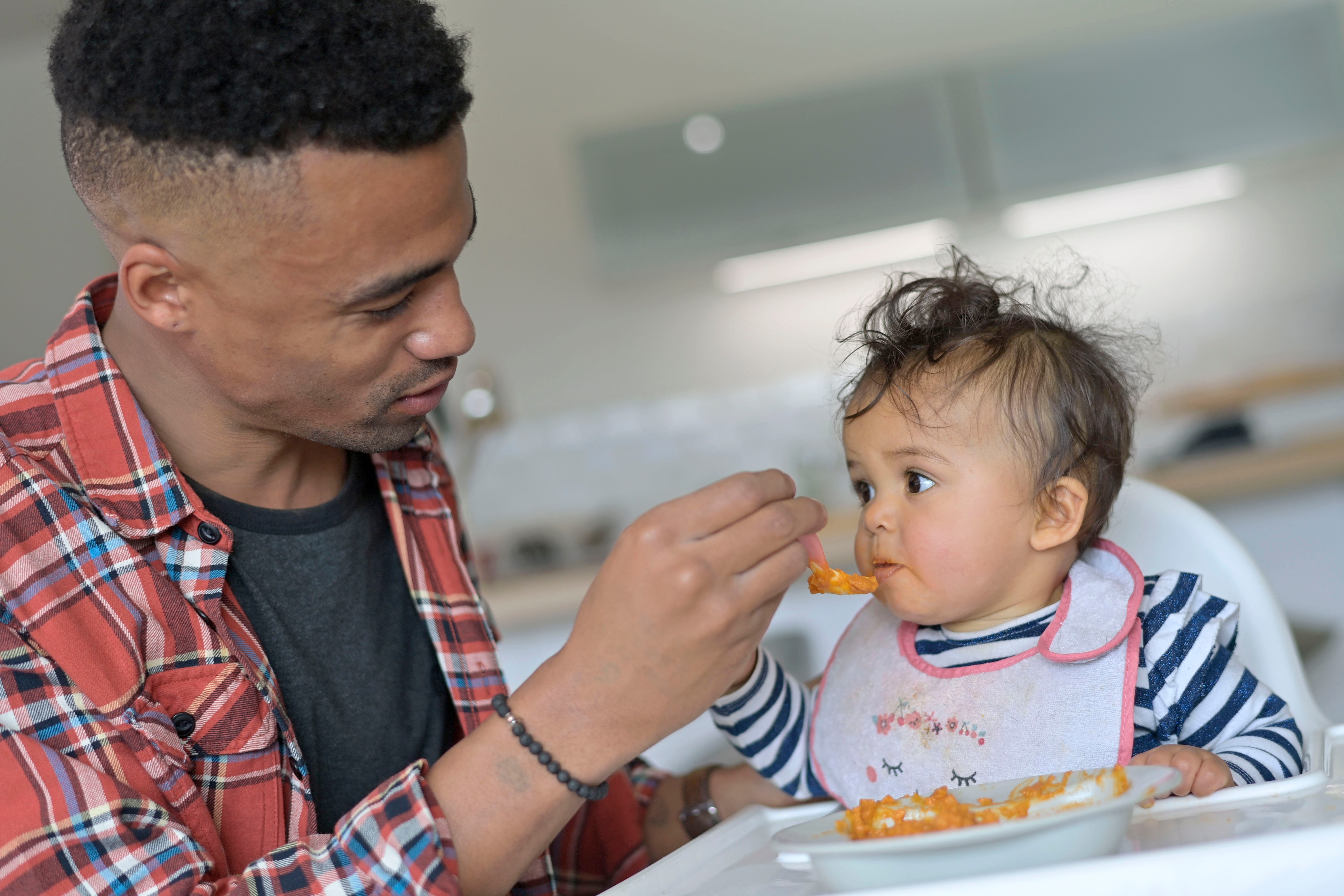 un papa nourri son bébé de pâtes