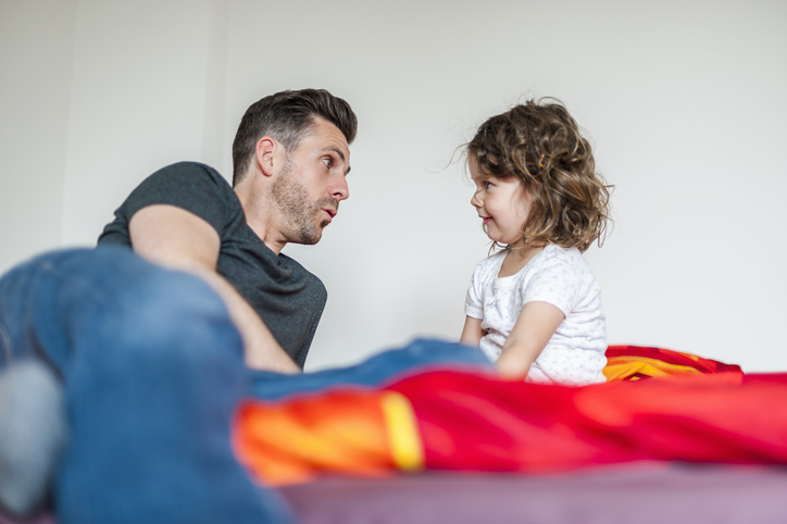 Adulte en train de parler à un enfant de 2 ans, visages à niveau. 