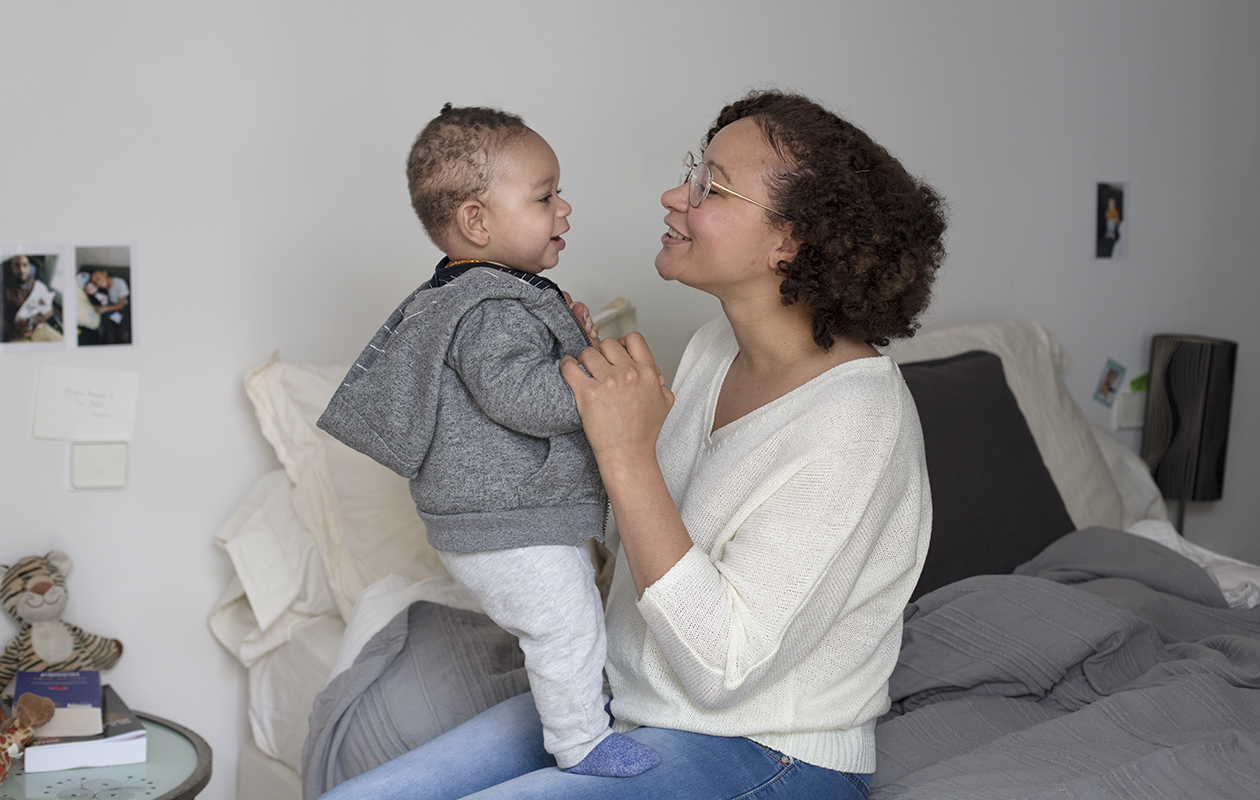 une maman aide son bebe à se tenir debout