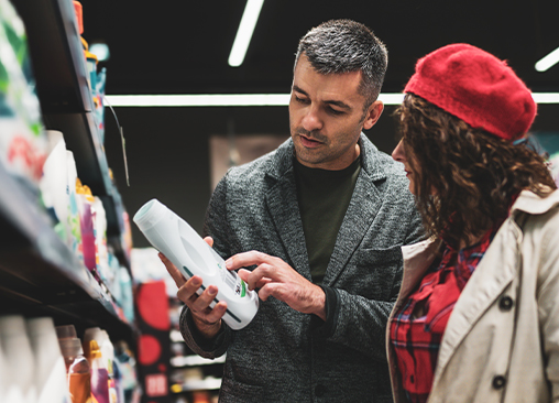 Un homme et une femme regardent l'étiquette d'un produit dans un magasin