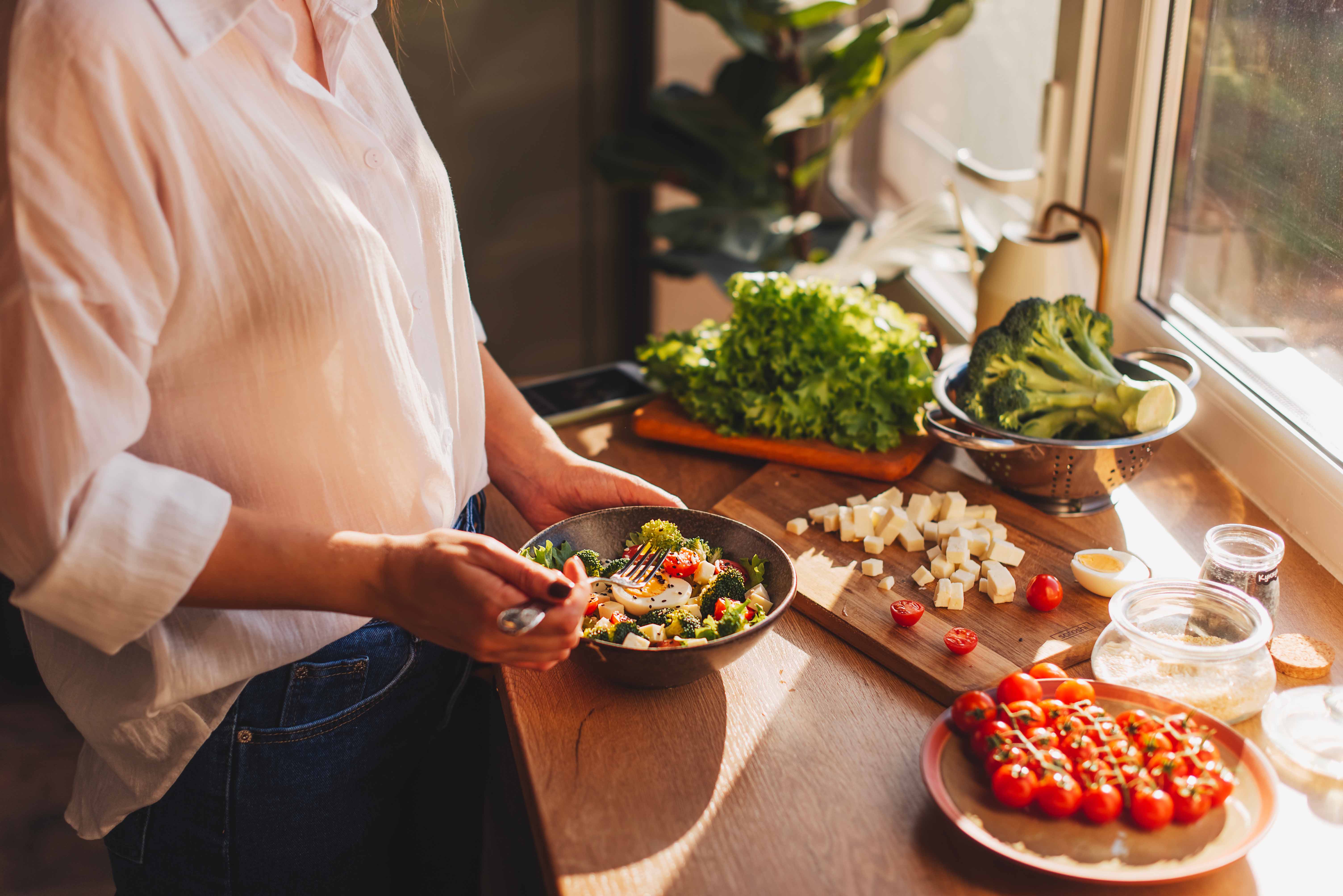 une femme prépare une salade de légumes