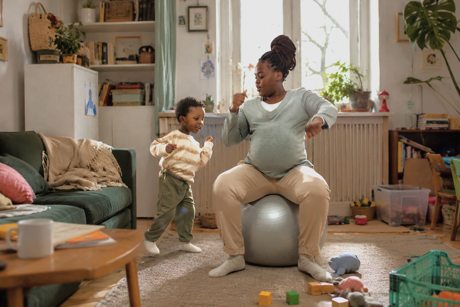 un jeune enfant danse à côté de sa maman dans son salon