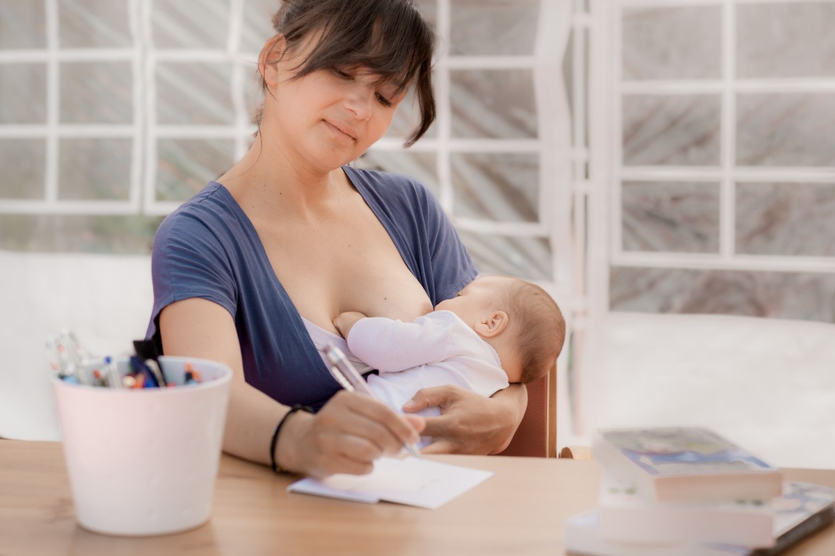 une maman allaite son bébé en travaillant
