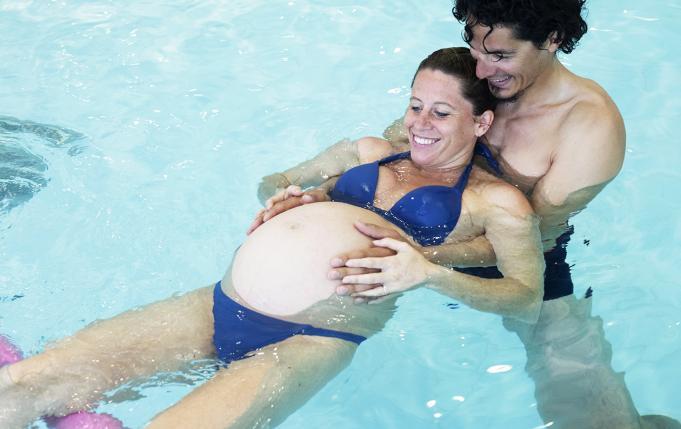 une femme enceinte et son compagnon à la piscine