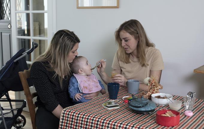 deux femmes dont une donne à manger à un bébé