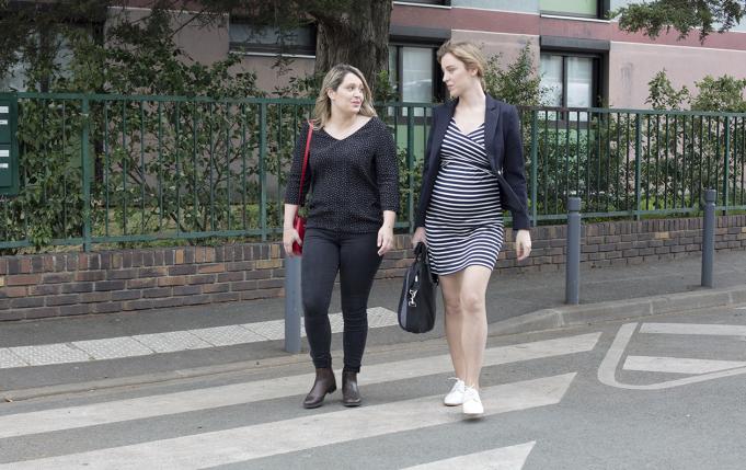 deux jeunes femmes traversent la rue en discutant