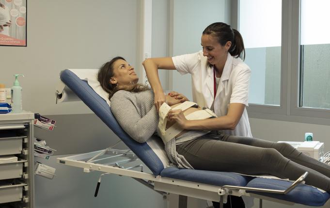 une sage-femme pose un monitoring sur une femme enceinte