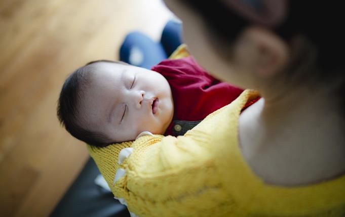 une femme tient un bébé dans ses bras