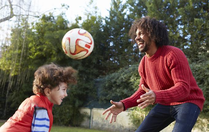 un homme joue au ballon avec un jeune garçon