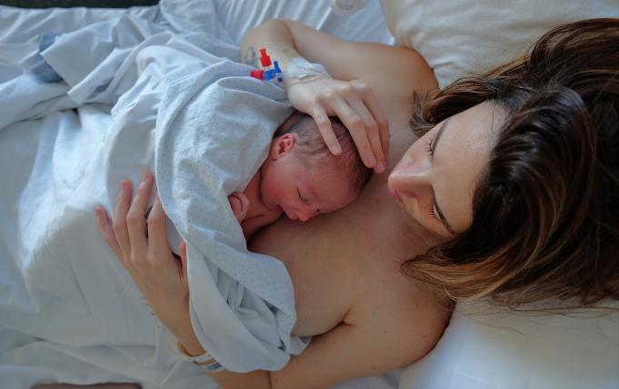 une femme avec son nouveau-né posé sur elle à la maternité