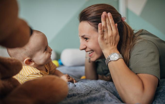 une femme joue à coucou-caché avec son bébé