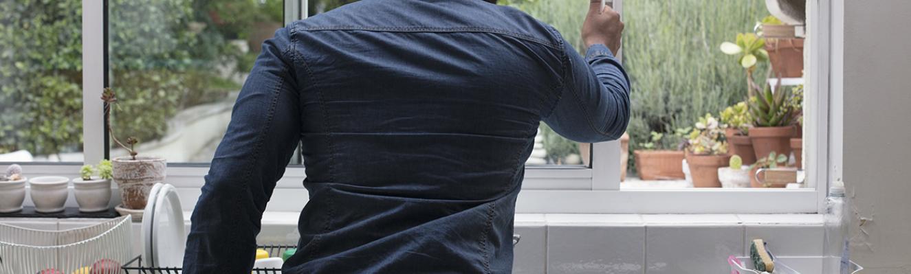 un homme ouvre la fenêtre de la cuisine