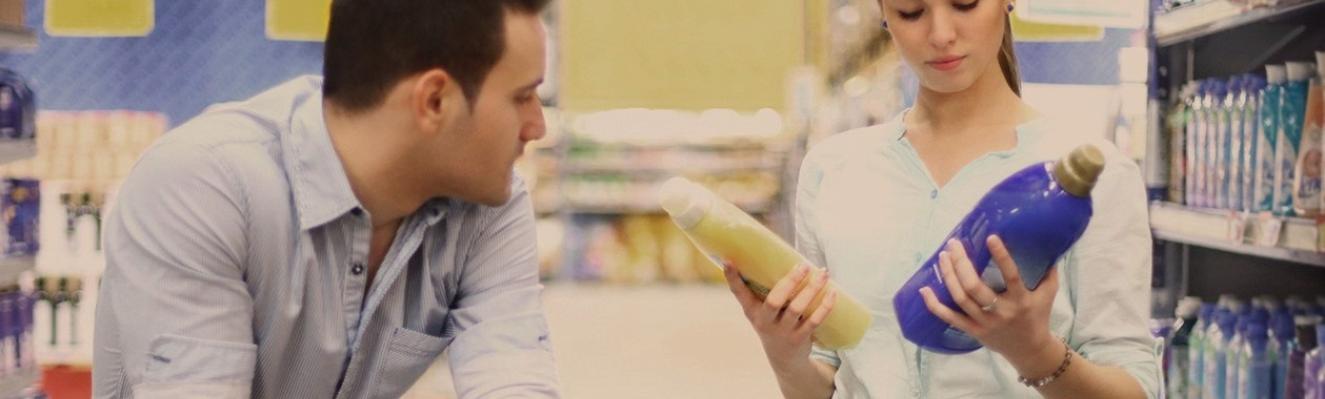 couple au supermarché qui compare deux bidons de lessive
