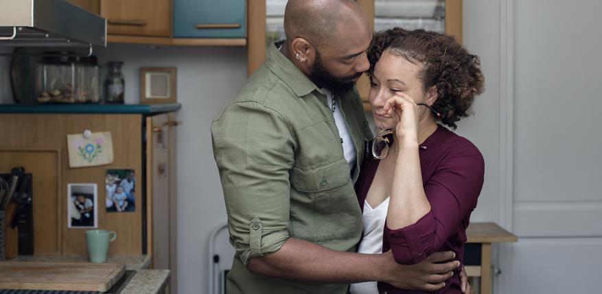 une femme pleure dans les bras de son compagnon