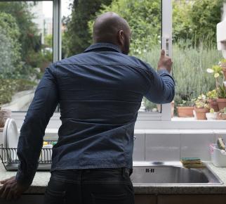 un homme ouvre la fenêtre de la cuisine
