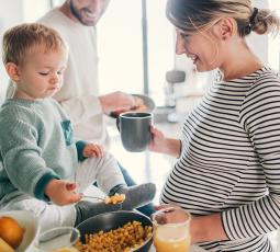 une femme enceinte, son compagnon et leur petit garçon préparent un plat de pois chiches