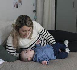 une maman et son bébé interagissent par la voix sur le lit