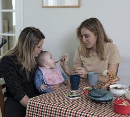 deux femmes dont une donne à manger à un bébé