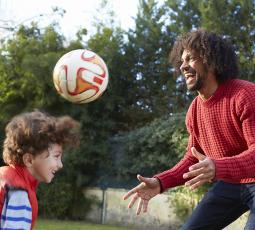 un homme joue au ballon avec un jeune garçon