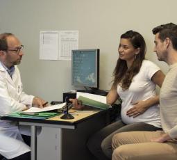 un couple dont la femme est enceinte dans le bureau d'un professionnel de santé