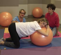 trois femmes dont une enceinte lors d'une séance de préparation a la naissance