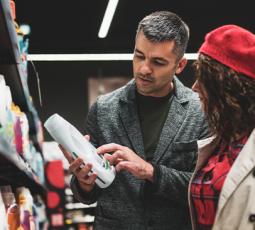 Un homme et une femme regardent l'étiquette d'un produit dans un magasin
